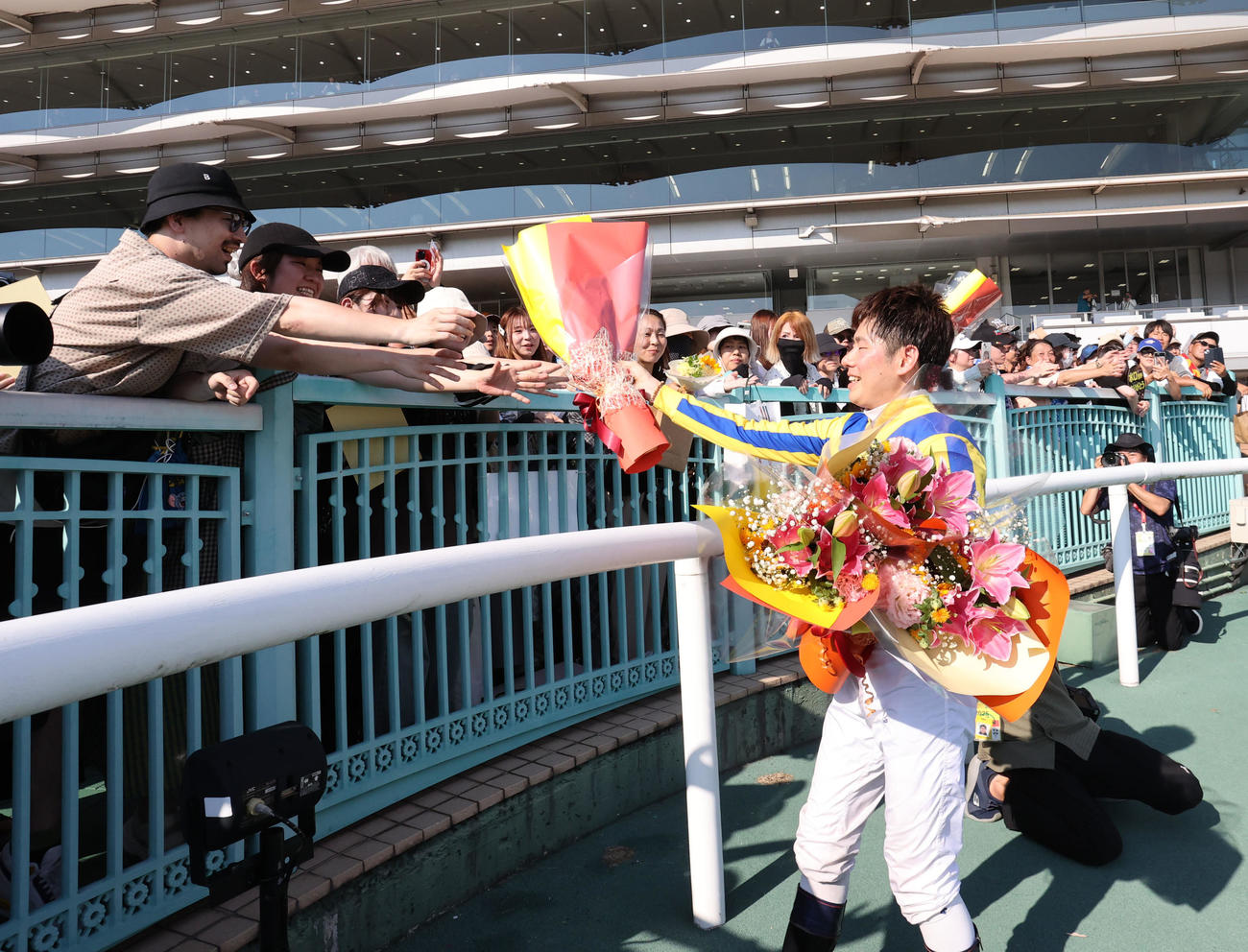 小倉競馬場での騎乗を終えた水口騎手はファンに花束を渡す（撮影・梅根麻紀）