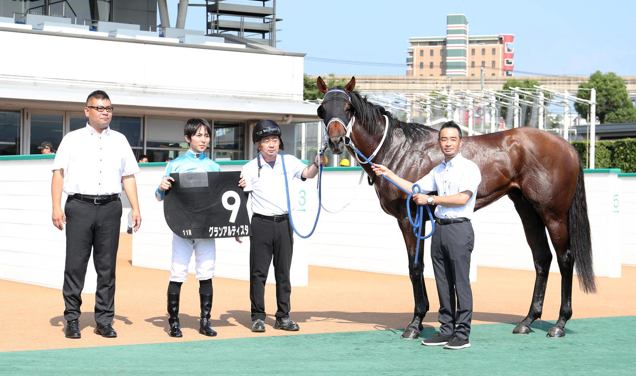 マレーシアCに勝利したグランアルティスタと口取りに並ぶ小崎騎手（左から2人目）（撮影・白石智彦）