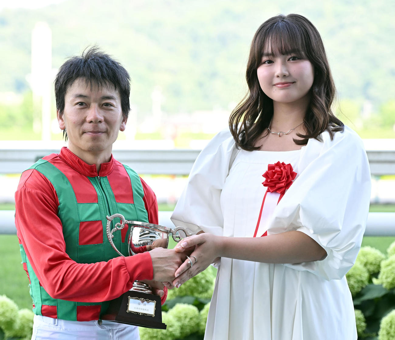 七夕賞をコスモフリーゲンで制し、プレゼンターを務めた俳優の箭内夢菜から握手で祝福を受ける柴田大騎手