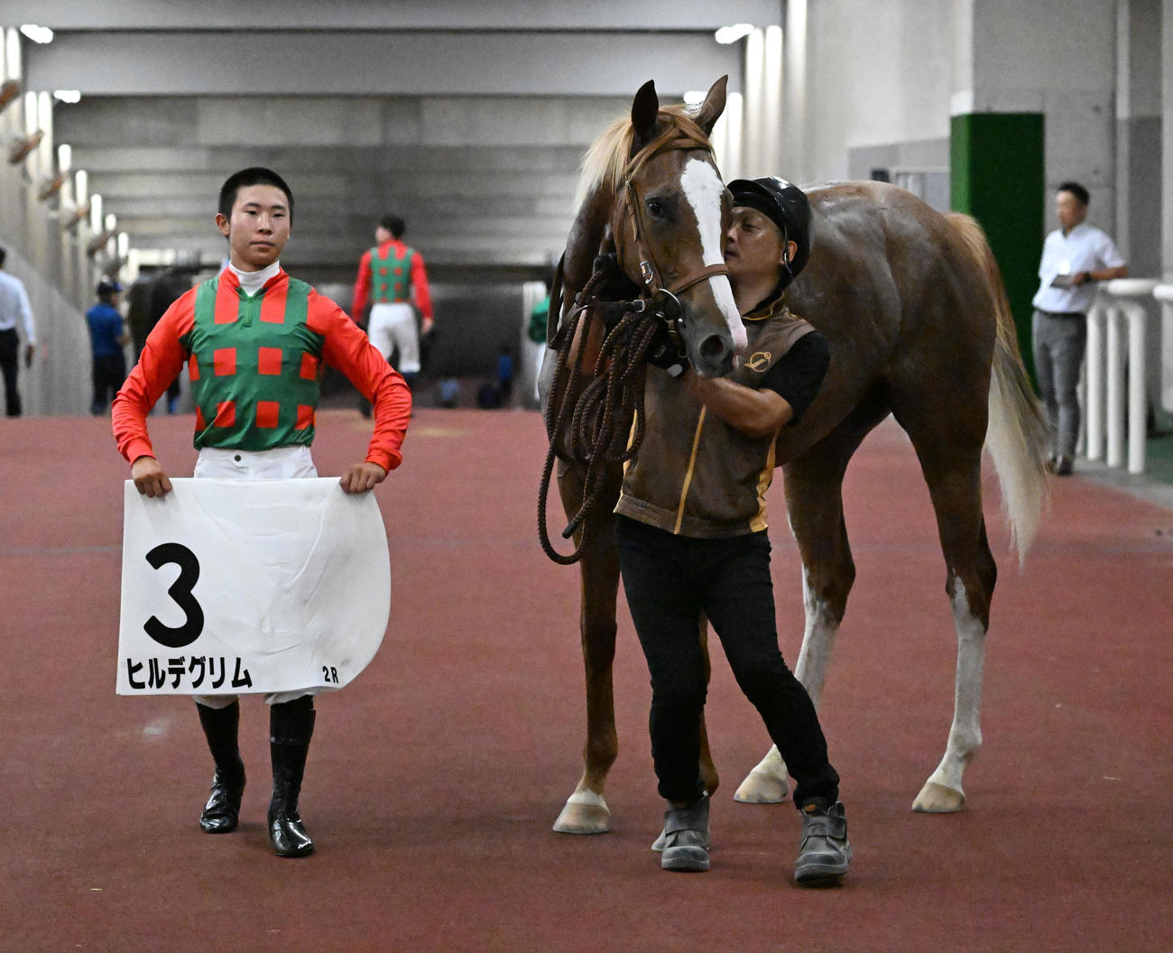 新潟2R、牝馬限定の2歳新馬戦を制したヒルデグリムの口取りをする石神道騎手（撮影・千葉一成）