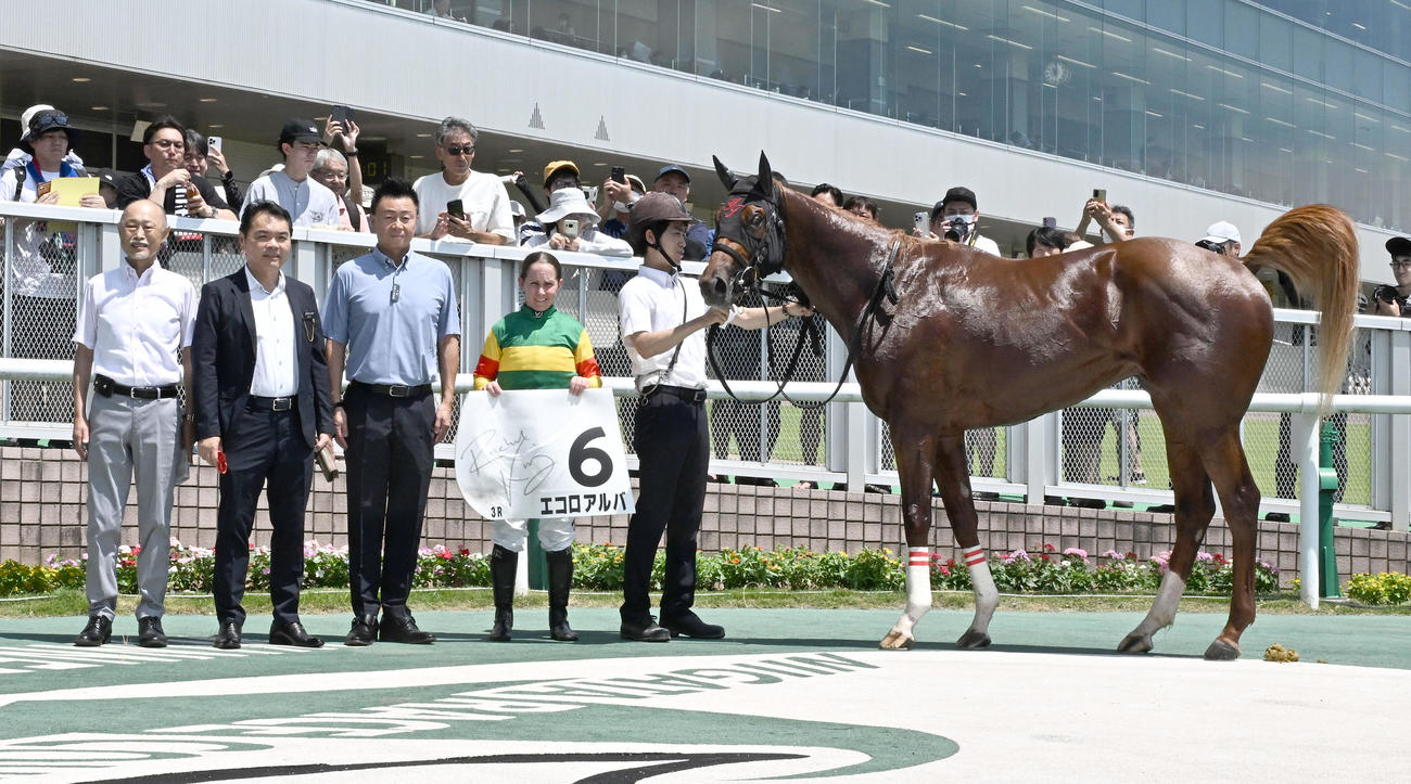 新潟3R、2歳新馬戦を制したエコロアルバの口取りをするキング騎手と田村師（左端）（撮影・千葉一成）