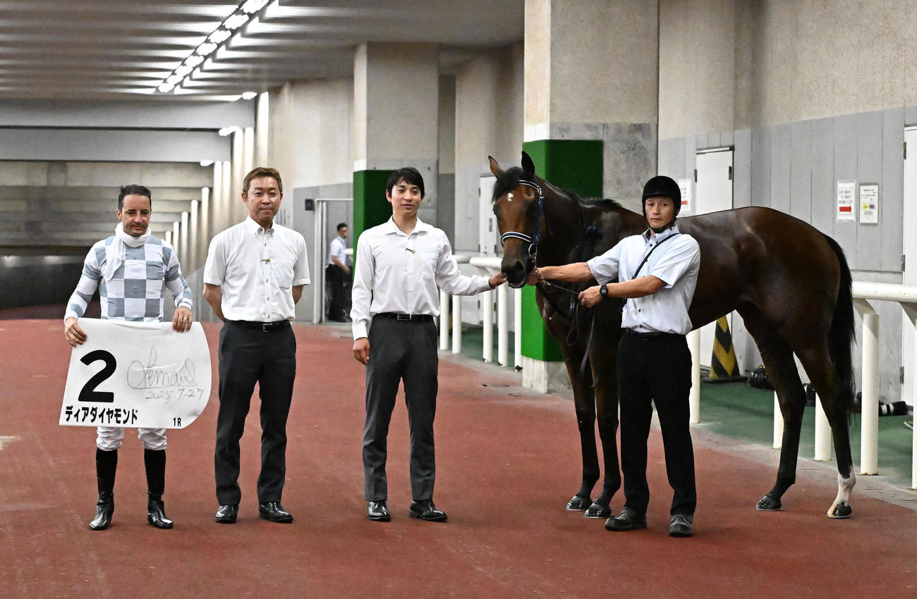 新潟1R、牝馬限定の2歳未勝利戦を制したディアダイヤモンドの口取りをするルメール騎手と手塚師（左から2人目）（撮影・千葉一成）