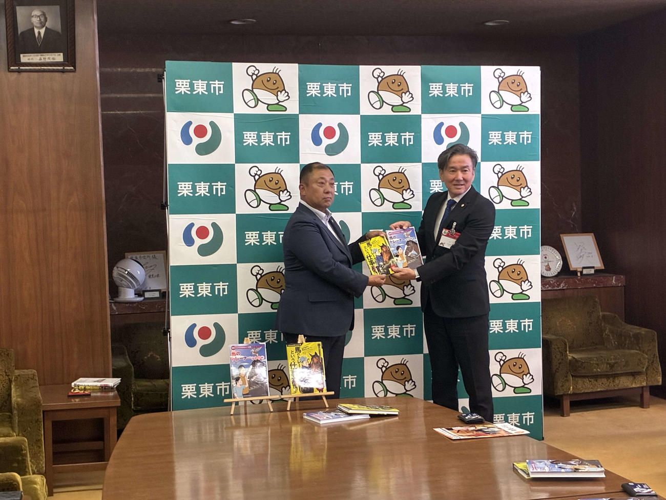 高橋義忠師から栗東市長竹村健市長に図書が寄贈された（撮影・明神理浩）