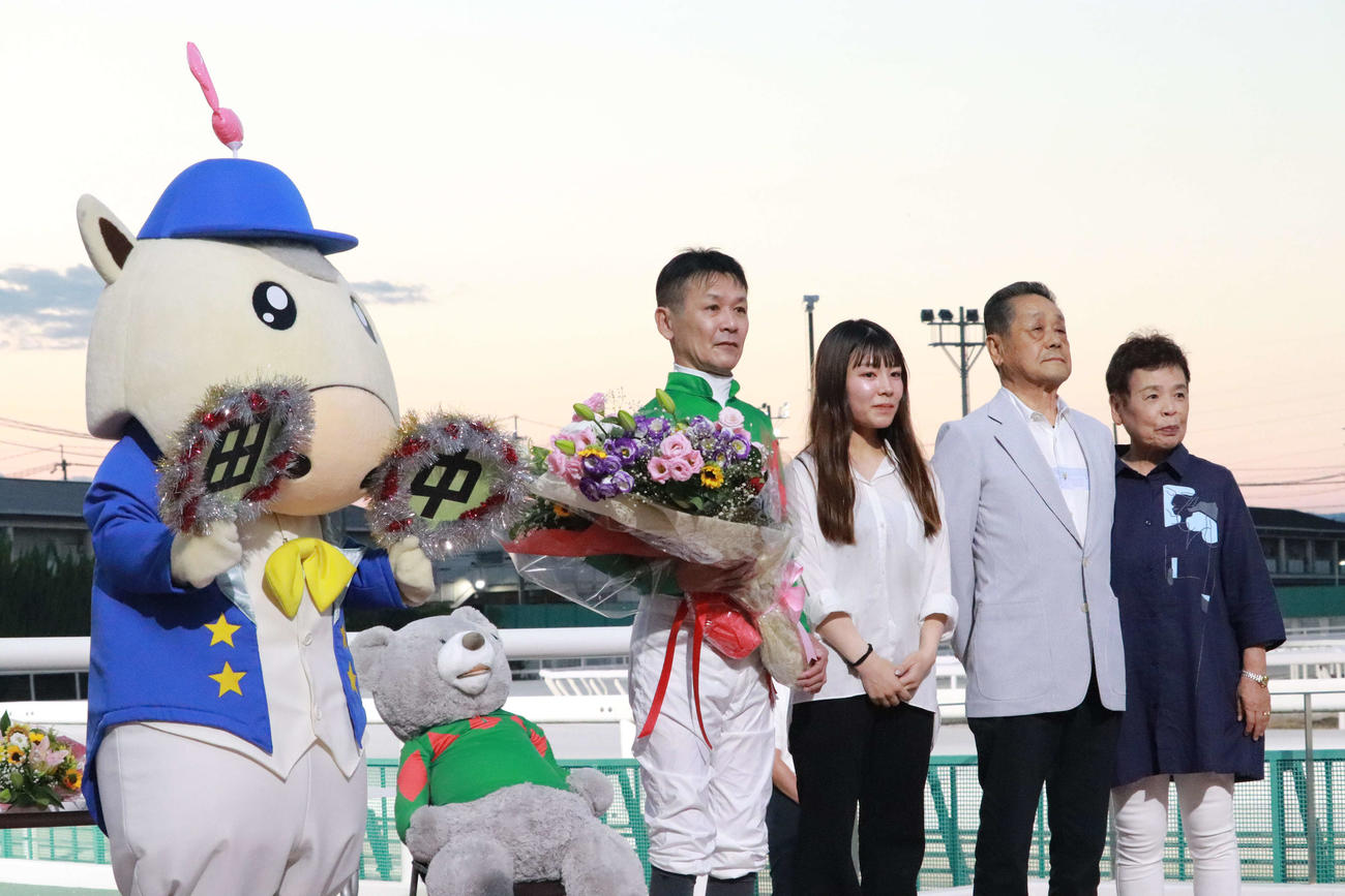 引退セレモニーで、花束を手に父・道夫師ら家族と写真撮影する田中学騎手