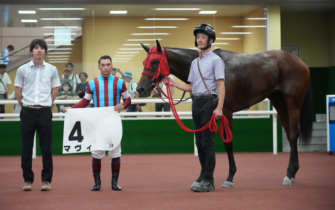 中京2R新馬戦を制し口取りするマヴィとバデル騎手（左から2人目）と関係者