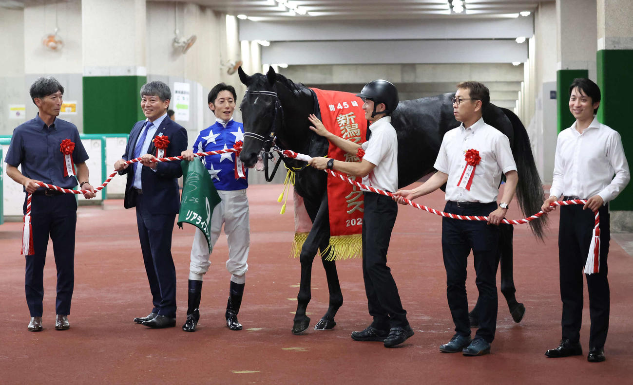 新潟2歳Sを制したリアライズシリウスの口取りをする津村騎手と手塚師（撮影・丹羽敏通）