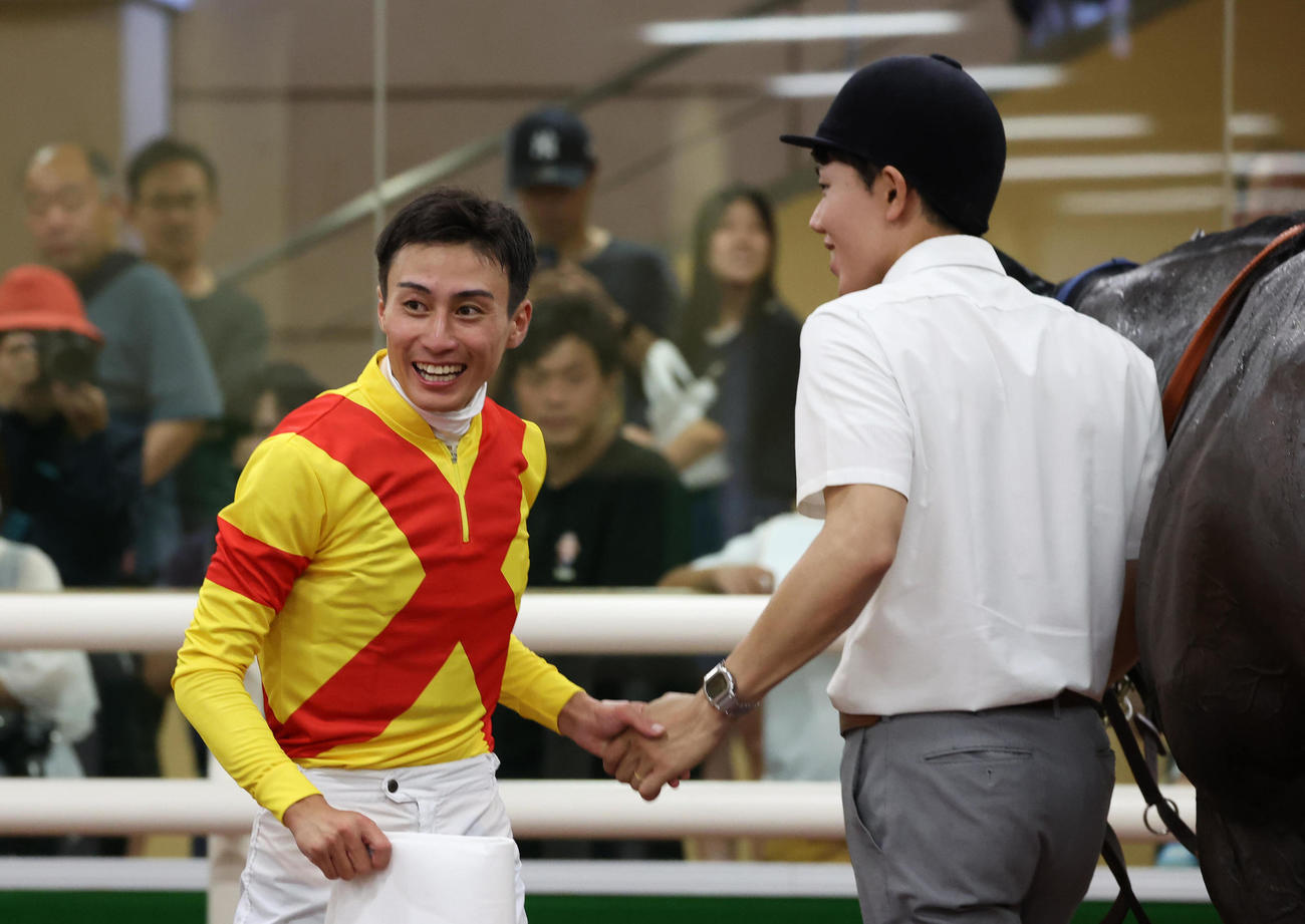 帰国後初勝利を挙げて笑顔の富田騎手（左）（撮影・白石智彦）
