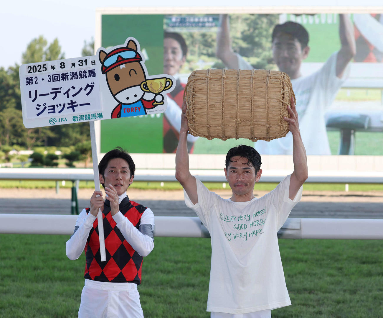 新潟リーディングジョッキーとなって副賞の米俵を掲げる戸崎騎手（撮影・丹羽敏通）