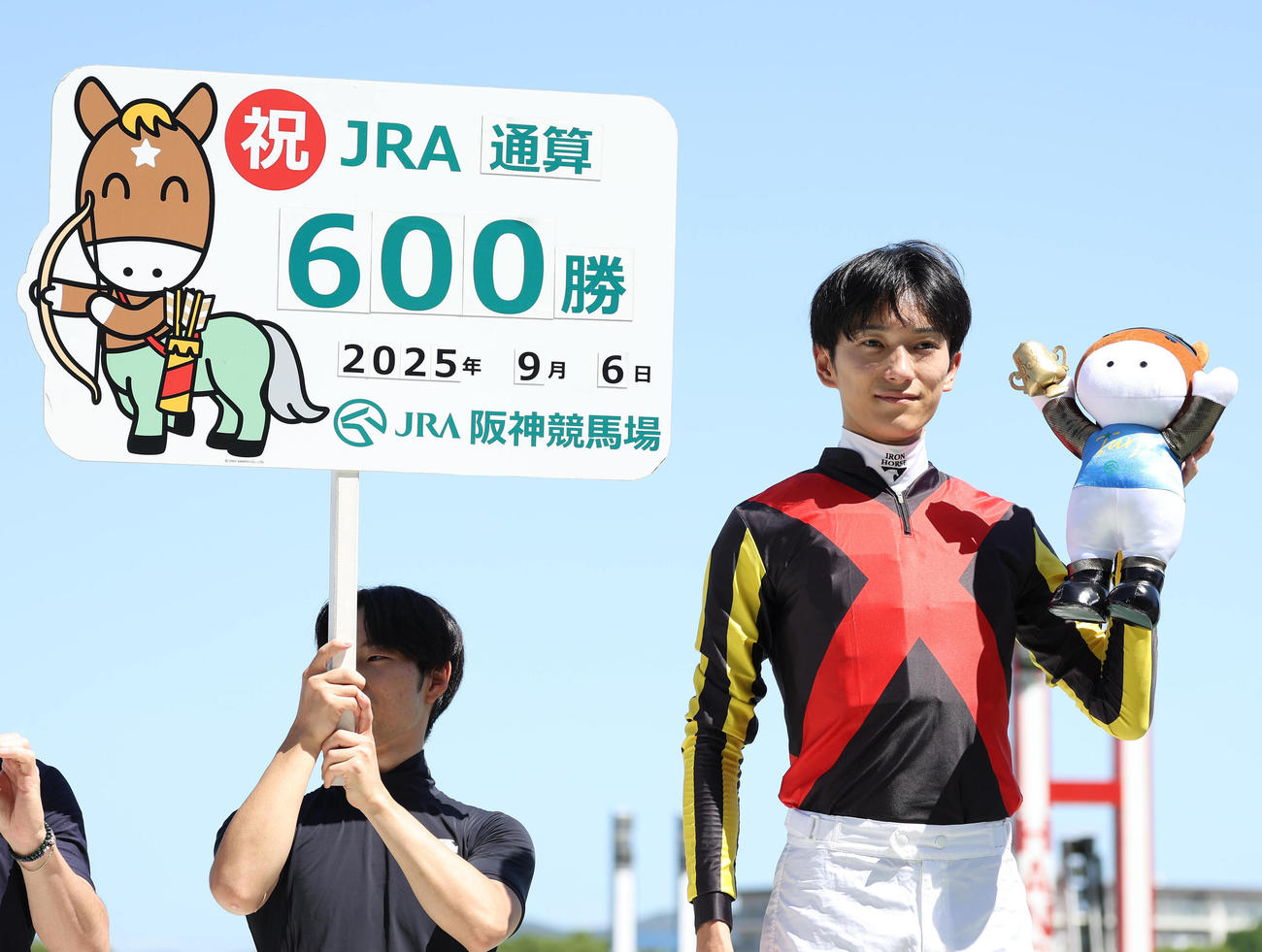 JRA通算600勝を達成してガッツポーズで記念写真に納まる坂井騎手（撮影・白石智彦）