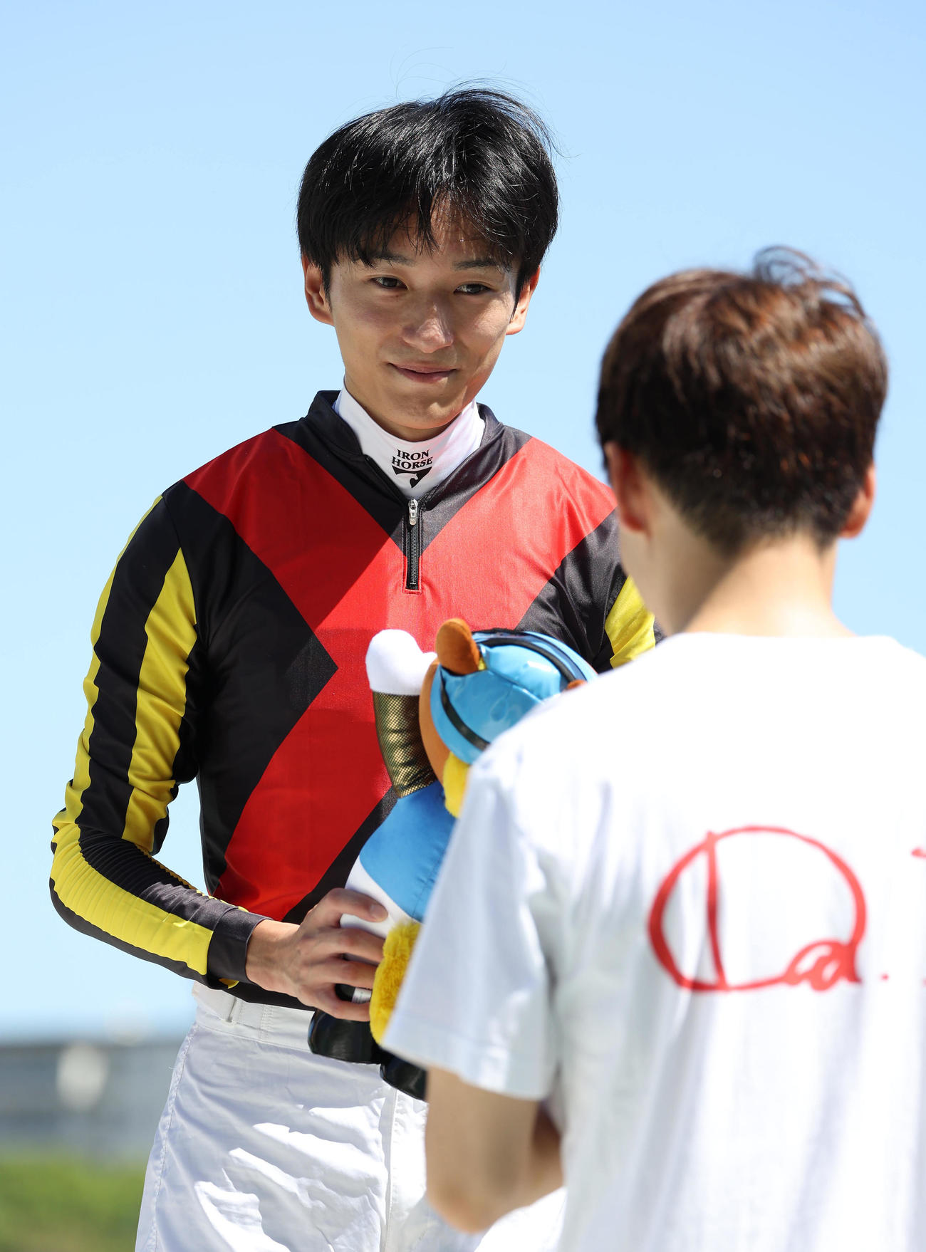 松山騎手から記念のターフィー人形を受け取る坂井騎手（撮影・白石智彦）