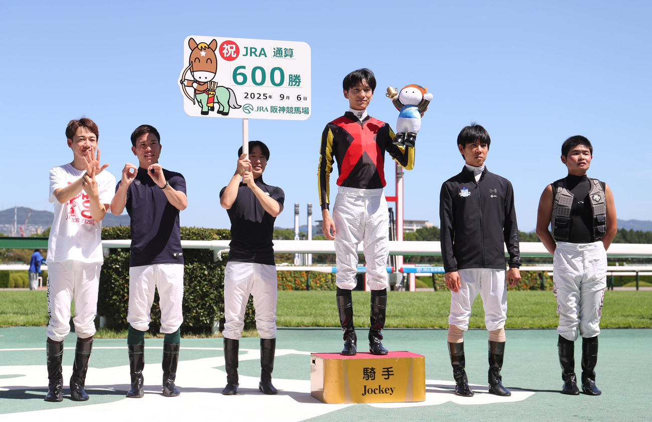 阪神2R、JRA通算600勝を達成してガッツポーズで記念写真に納まる坂井騎手（右から3人目）（撮影・白石智彦）