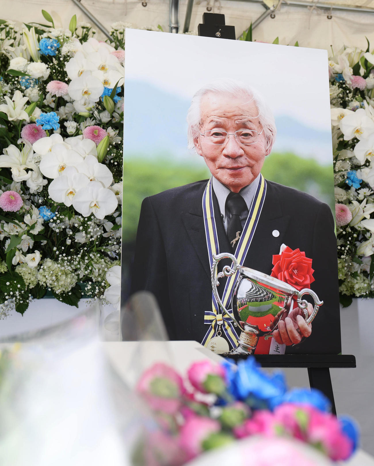 阪神競馬場ではメイショウの勝負服に合わせられた花が手向けられた松本好雄オーナーの献花台が設置