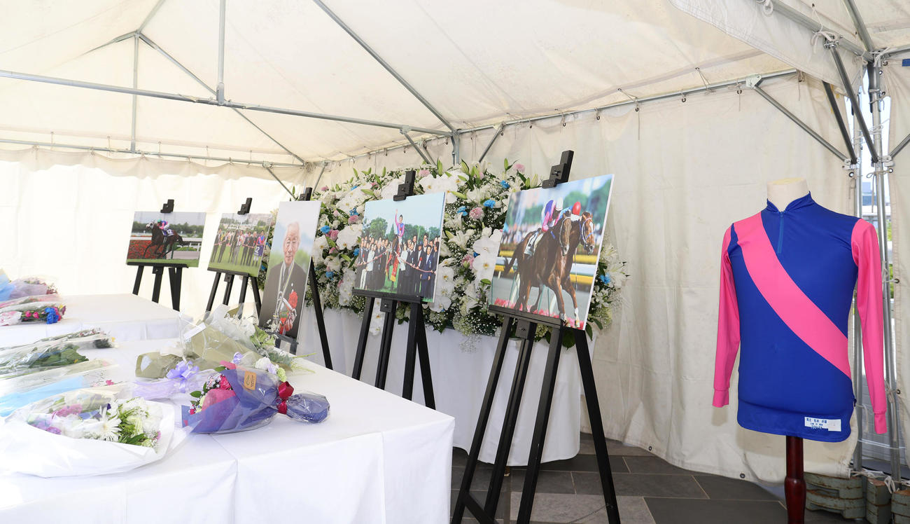 阪神競馬場に設置されたメイショウの松本好雄オーナーの献花台と勝負服（撮影・白石智彦）