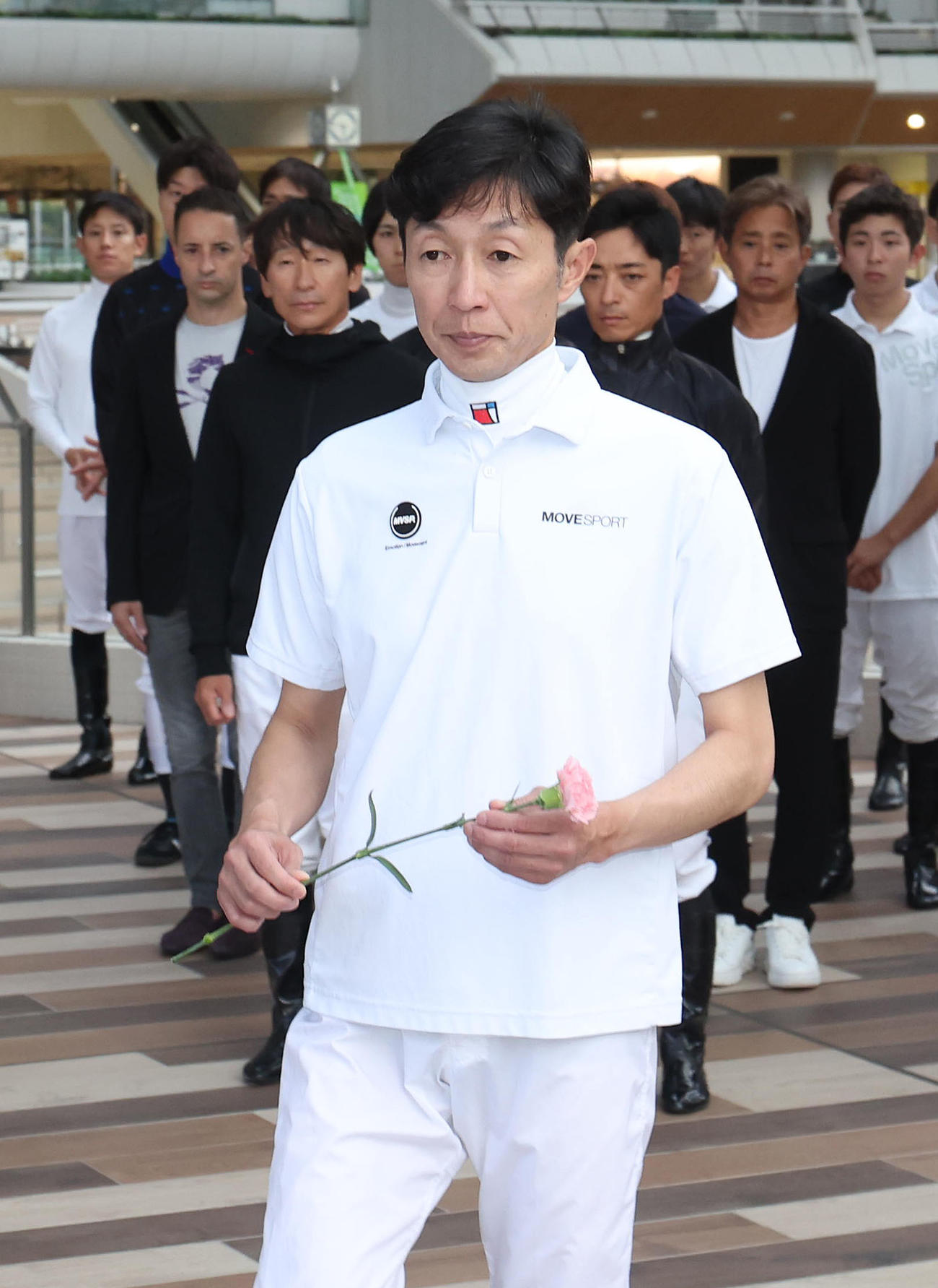 故松本好雄オーナーの献花台にピンクのカーネーションを手向ける武豊騎手（撮影・白石智彦）