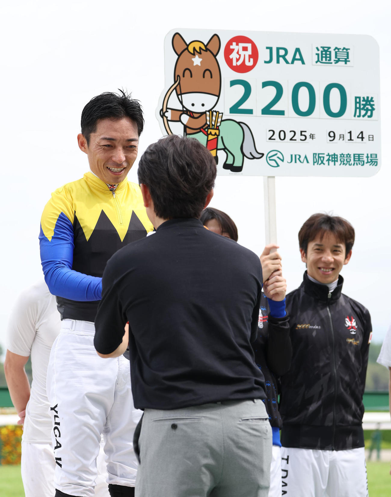 阪神2R、JRA通算2200勝を達成して福永師（右）からターフィー人形を渡される川田騎手（撮影・白石智彦）