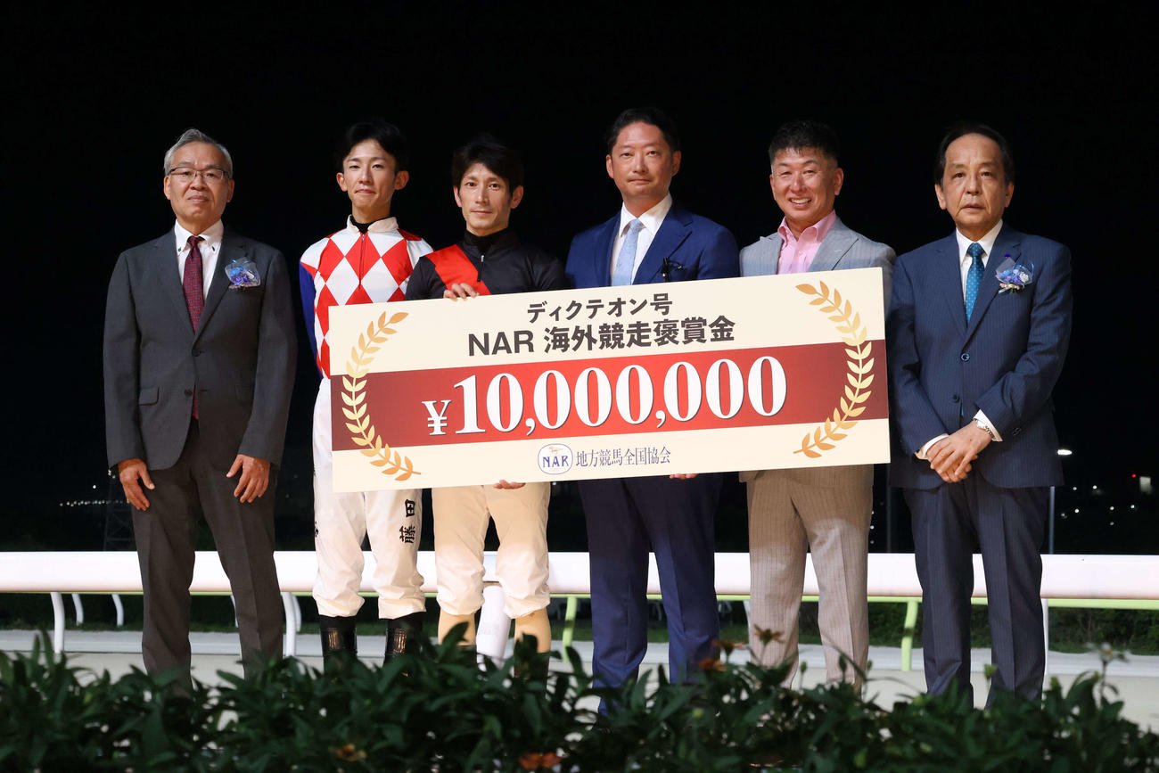 コリアC優勝報告会の記念撮影に納まるディクテオンの関係者