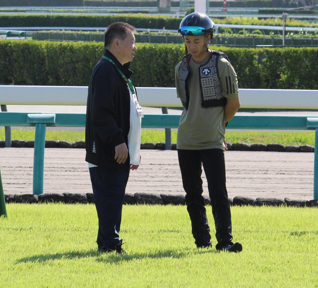 中山競馬場の芝コースを歩き、話し合うK・マン師（左）とK・リョン騎手（撮影・深田雄智）