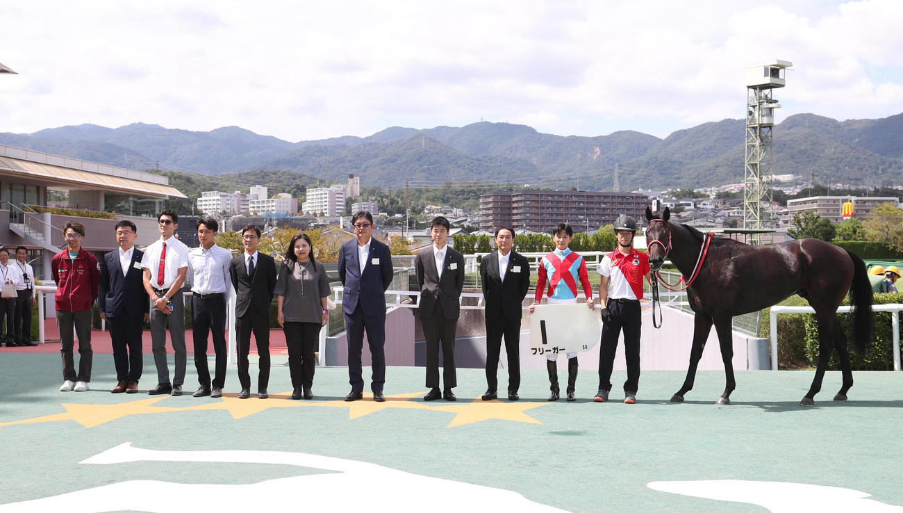 阪神5R、新馬戦を制したフリーガーと口取りに並ぶ坂井騎手（右から2人目）（撮影・白石智彦）