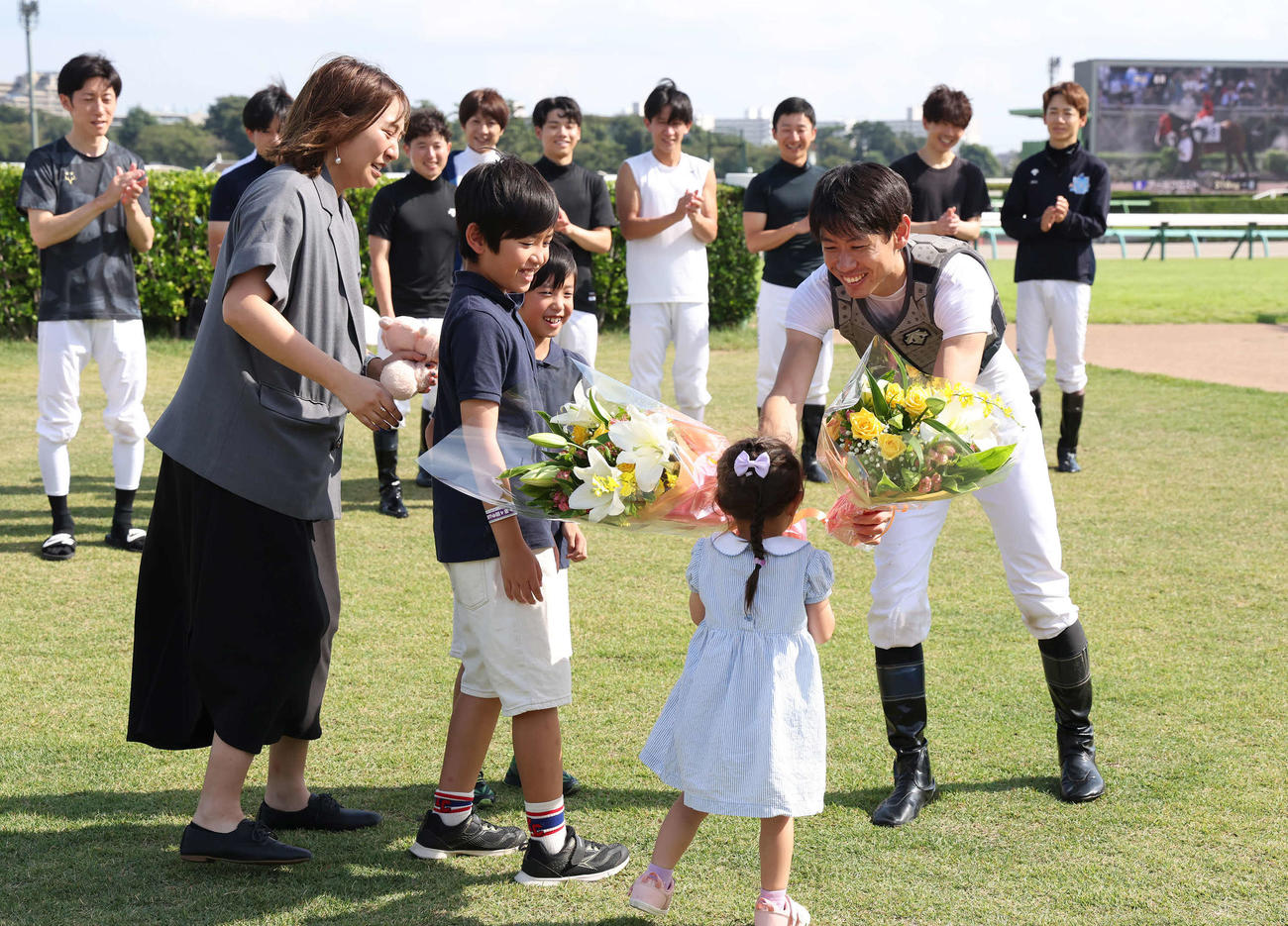 家族から花束を受け取る宮崎騎手（撮影・丹羽敏通）