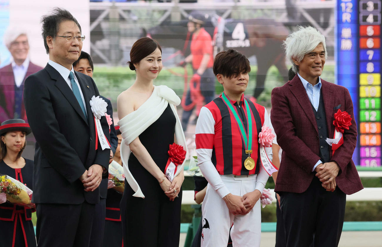 プレゼンターの松本若菜（左から2人目）、佐藤浩市（右端）らと写真に納まる三浦騎手（撮影・丹羽敏通）