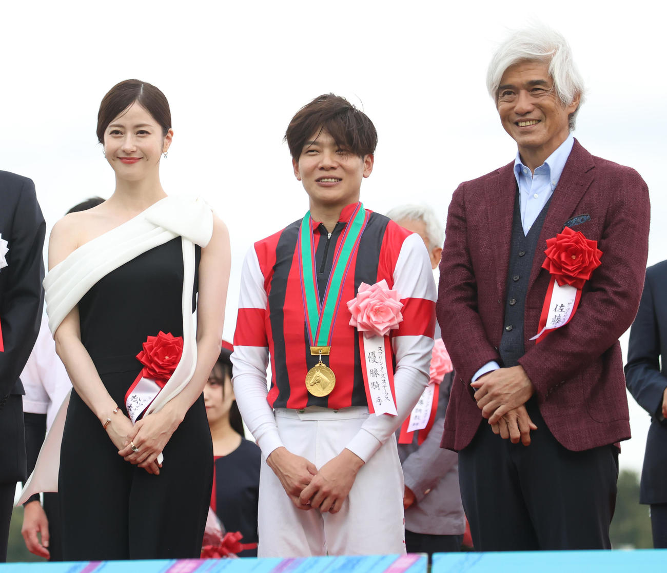スプリンターズSの表彰式で三浦騎手（中央）は松本若菜（左）、佐藤浩市と記念撮影に納まる　