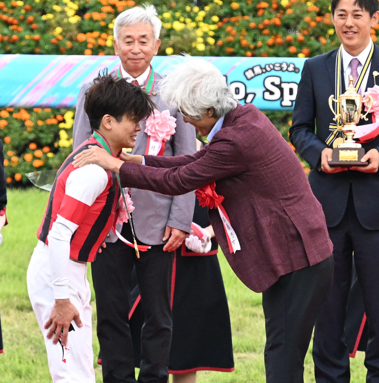 スプリンターズSの表彰式で、佐藤浩市（右）から優勝メダルを掛けられ感極まる三浦騎手