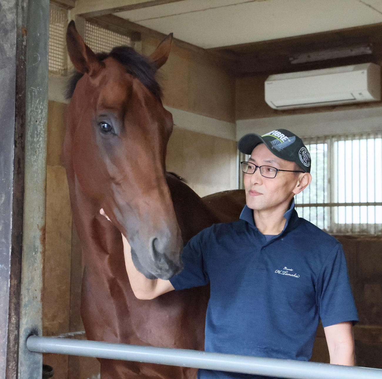 ジャパンダートCの優勝から一夜明けて、担当の田端厩務員に甘えるナルカミ（撮影・丹羽敏通）
