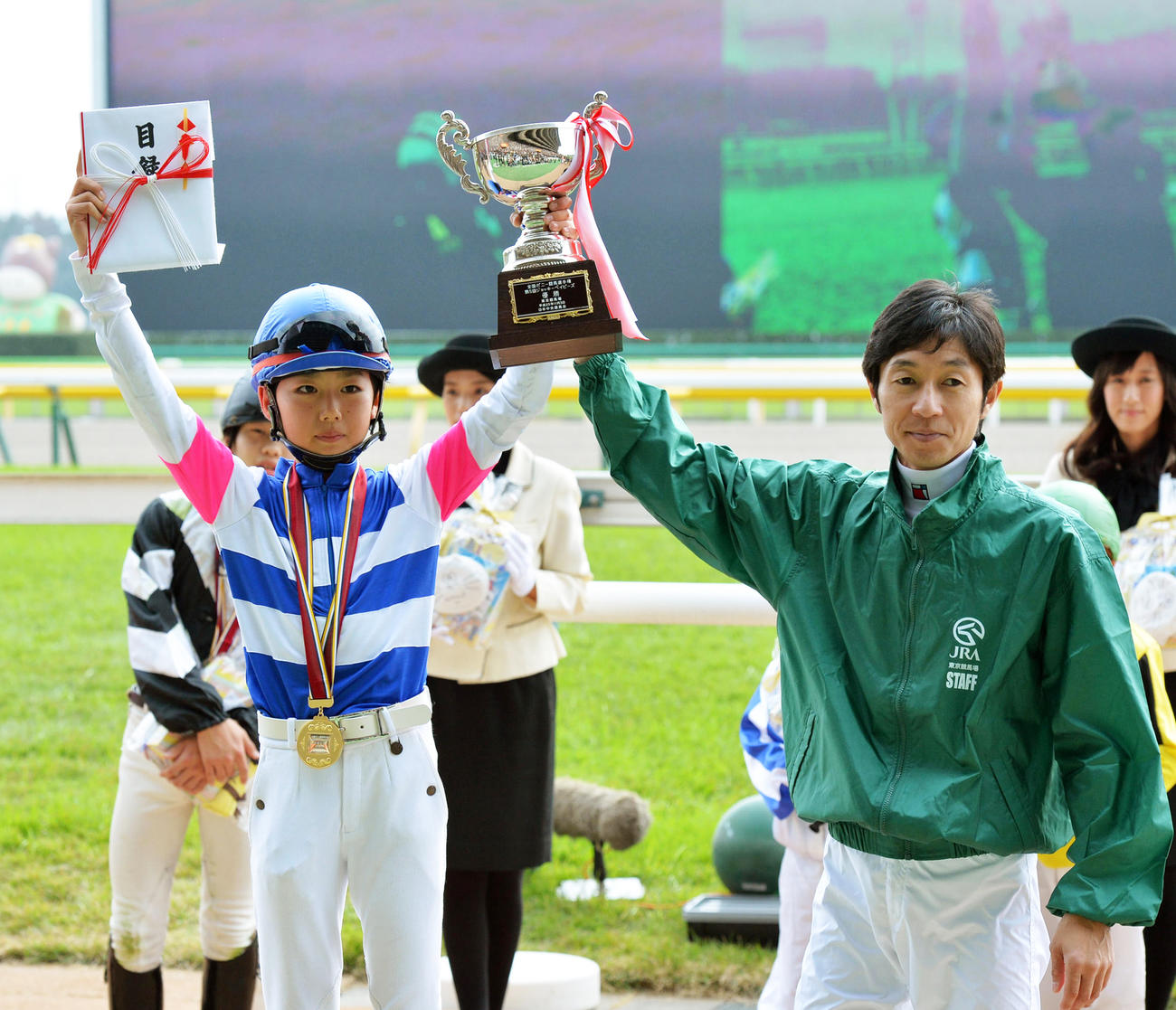 13年ジョッキーベイビーズで優勝した斎藤新さんはプレゼンターの武豊騎手とポーズ