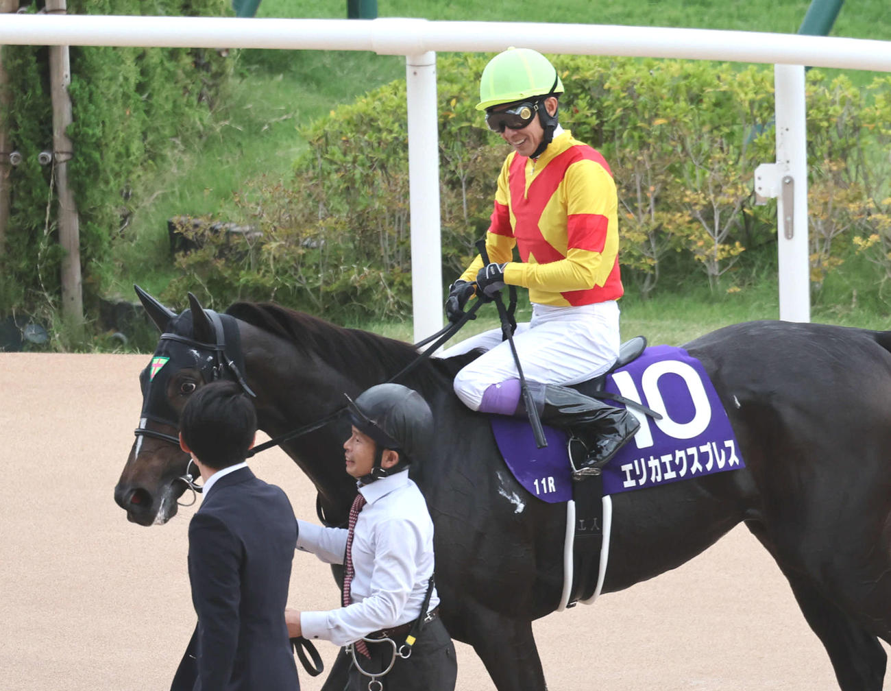 エリカエクスプレスで秋華賞2着となった武豊騎手は関係者と笑顔で話しながら引き揚げる（撮影・西尾就之）