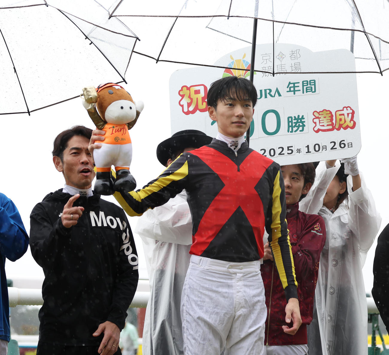 京都9R、JRA年間100勝を達成しターフィー人形を掲げて記念写真に納まる坂井騎手（撮影・白石智彦）