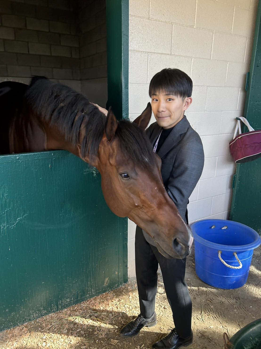 BCターフスプリントに挑むインビンシブルパパはデルマー競馬場内の馬房で佐々木騎手とふれ合う（伊藤大士調教師提供）