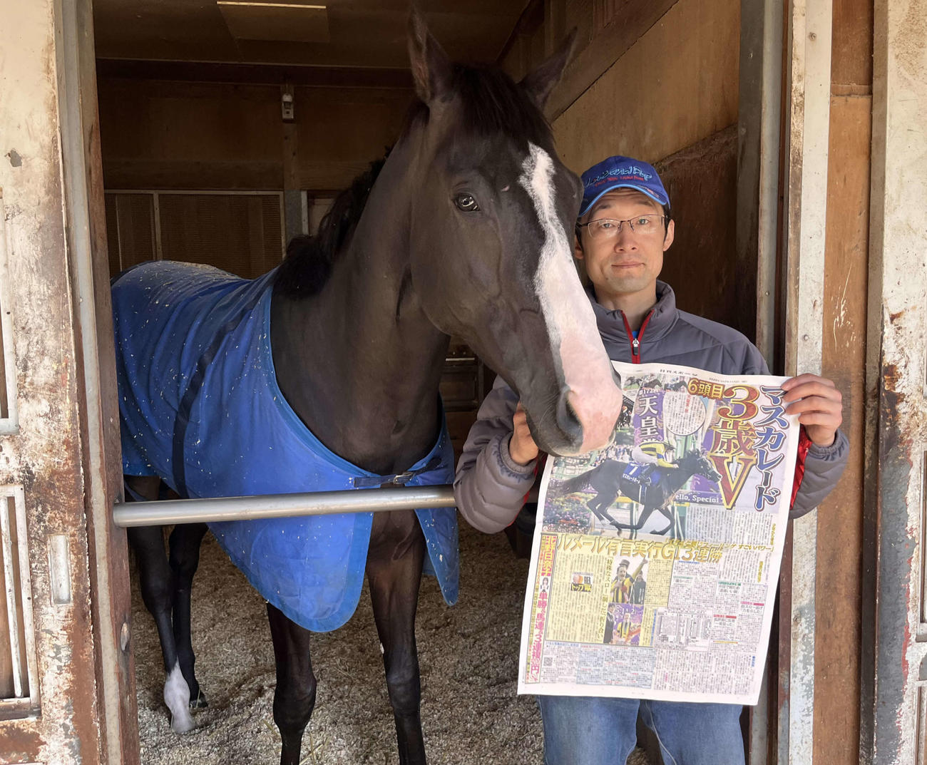 天皇賞・秋を制したマスカレードボールは一夜明け、美浦トレセンの馬房内で担当の花本助手と記念撮影