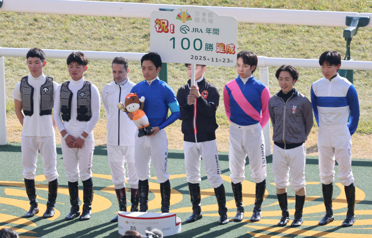 京都1R、川田騎手（中央）は2歳未勝利戦をホットシートで勝ち年間100勝を達成、騎手仲間と記念写真に納まる（撮影・西尾就之）