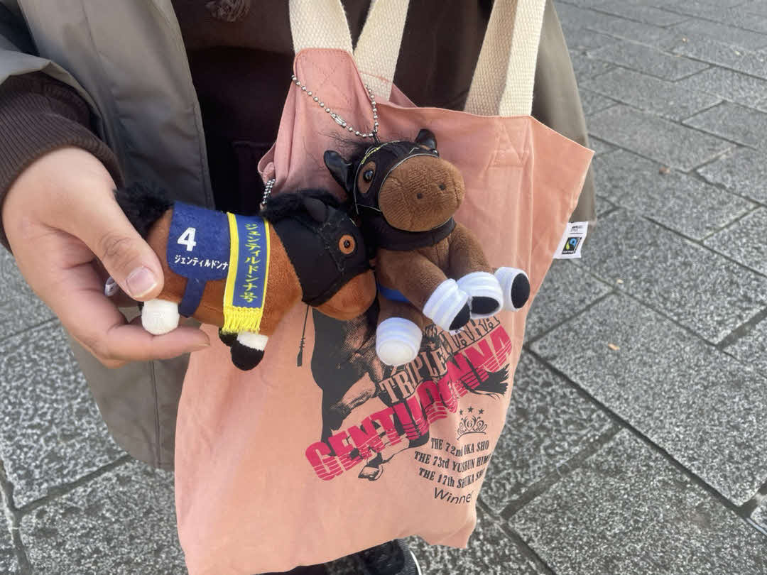 ジェンティルドンナのバッグにぬいぐるみ2体をつけて献花台を訪れた女性ファン