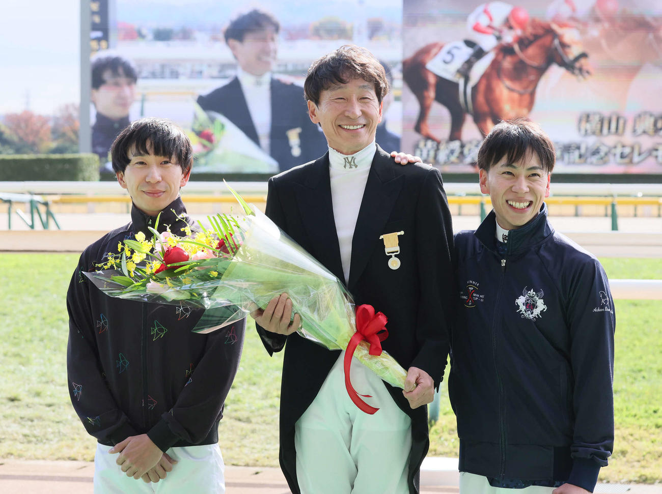 黄綬褒章受賞セレモニーで2人の息子和生騎手（左）、武史騎手（右）と写真に納まる横山典騎手（撮影・丹羽敏通）
