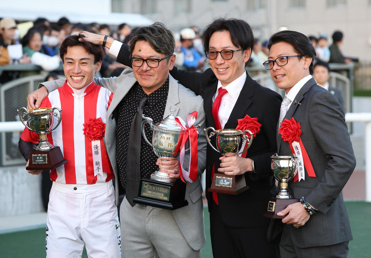 笑顔で記念写真に納まる、左から富田騎手、岡田隆寛オーナー、武英師、荻野助手（撮影・白石智彦）