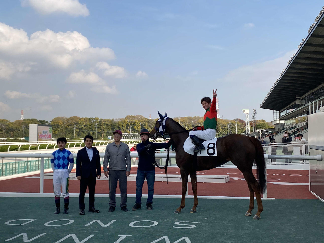 2日園田7Rで22年ぶりに年間200勝を達成して、馬上で2本指を掲げる小牧太騎手