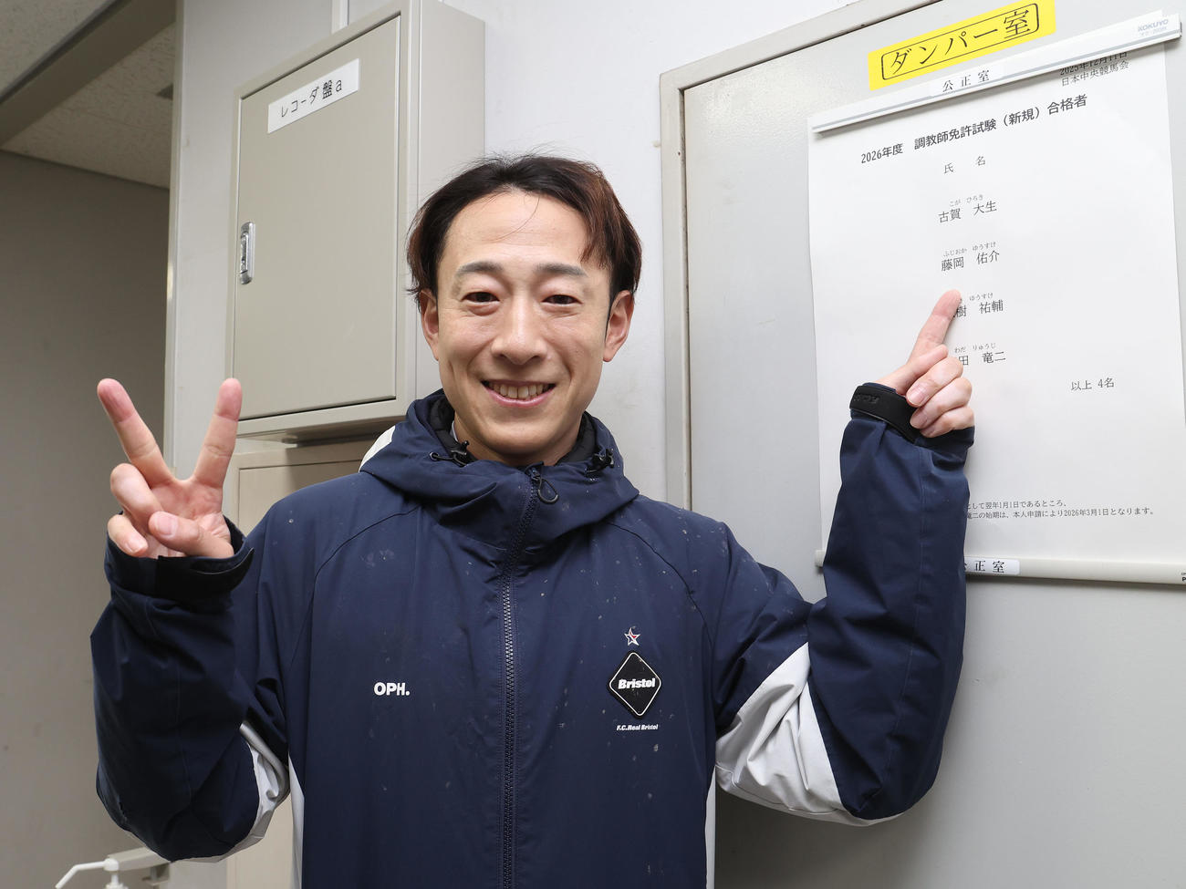 晴れて調教師試験に合格し合格者名簿の前で笑顔でピースする藤岡佑騎手（撮影・白石智彦）
