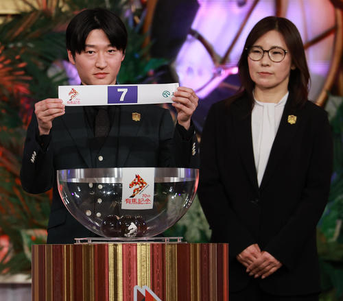 有馬記念公開枠順抽選会で4枠7番を引いたサンライズジパングの鮫島駿騎手。右は前川師（撮影・野上伸悟）
