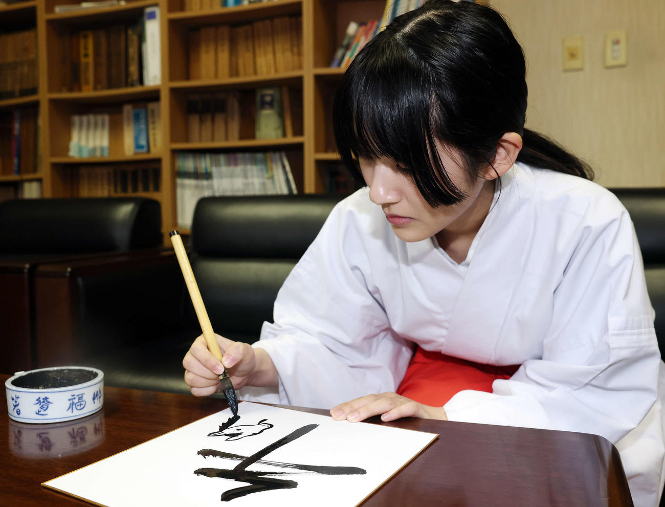 馬の絵を描く穴守稲荷神社の巫女の菊竹夏希さん（撮影・宮地輝）