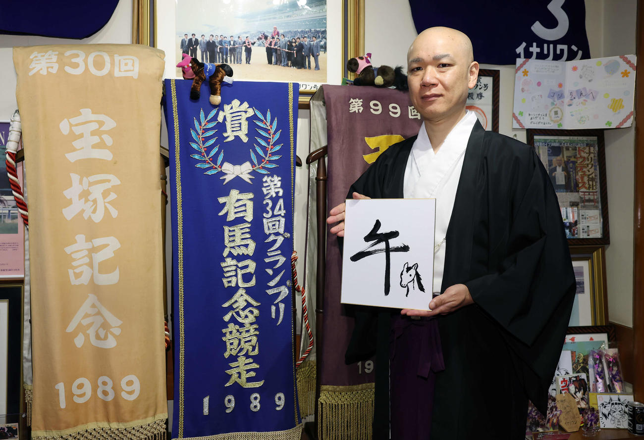 「午」と記した色紙を手にする穴守稲荷神社の宮司の井上直洋さん（撮影・宮地輝）