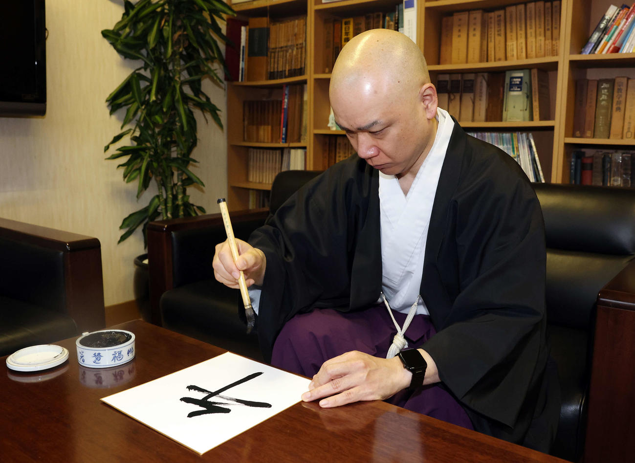 「午」と記す穴守稲荷神社の宮司の井上直洋さん（撮影・宮地輝）