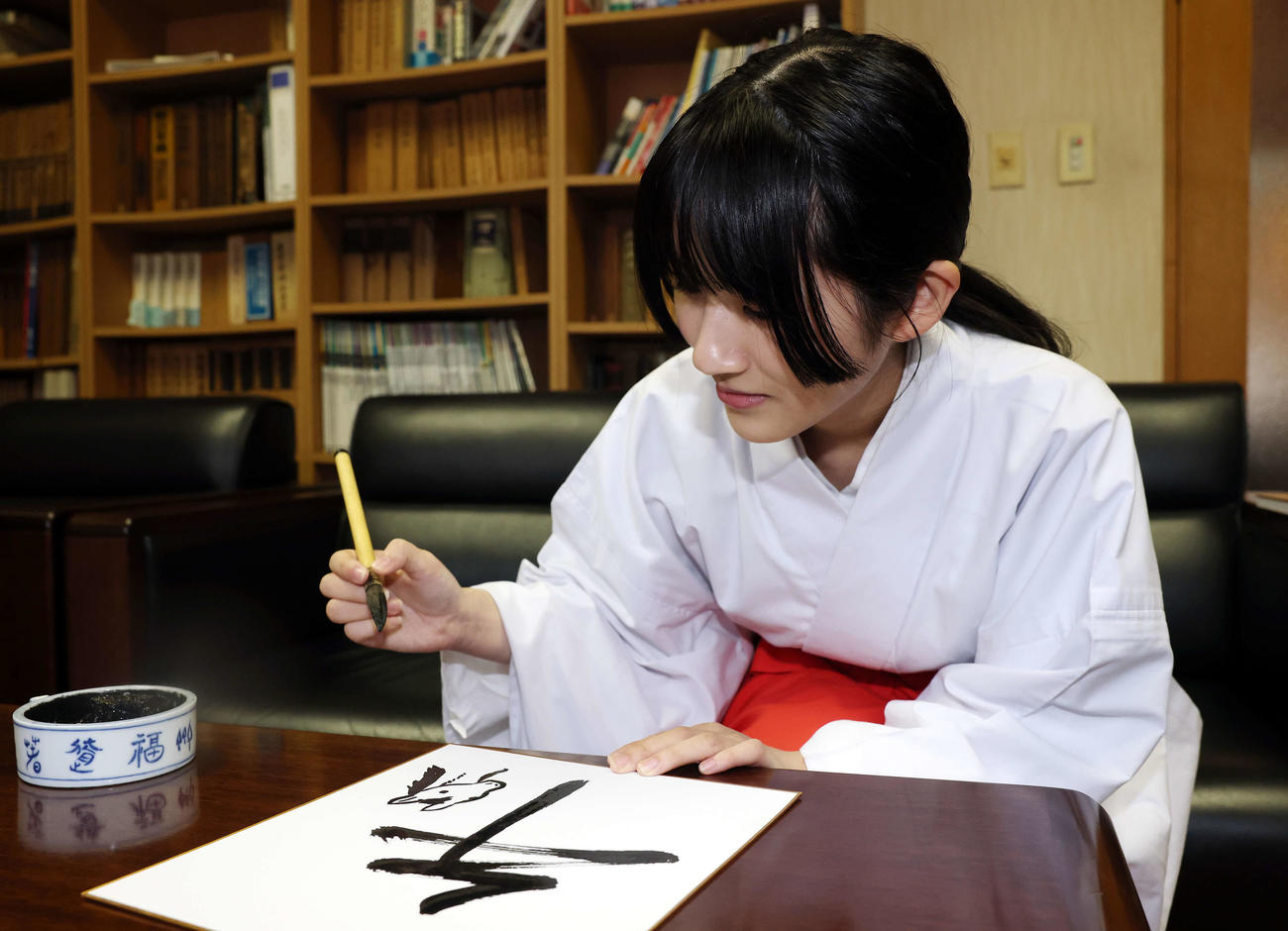 馬の絵を描く穴守稲荷神社の巫女の菊竹夏希さん（撮影・宮地輝）