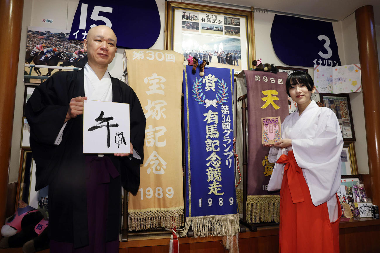 「午」と記した穴守稲荷神社の宮司の井上直洋さん（左）と自身がデザインした御朱印帳を手にする巫女の菊竹夏希さん（撮影・宮地輝）