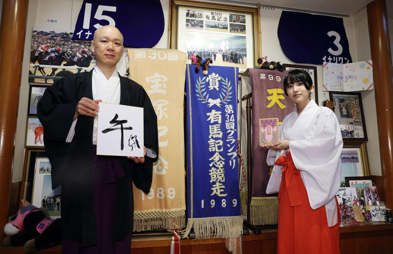 「午」と記した穴守稲荷神社の宮司の井上直洋さん（左）と自身がデザインした御朱印帳を手にする巫女の菊竹夏希さん（撮影・宮地輝）