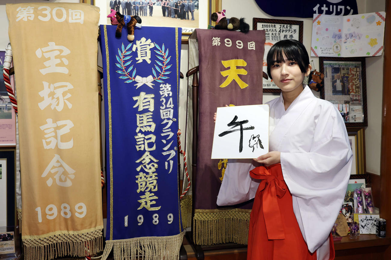 馬の絵を描いた色紙を手にする穴守稲荷神社の巫女の菊竹夏希さん（撮影・宮地輝）