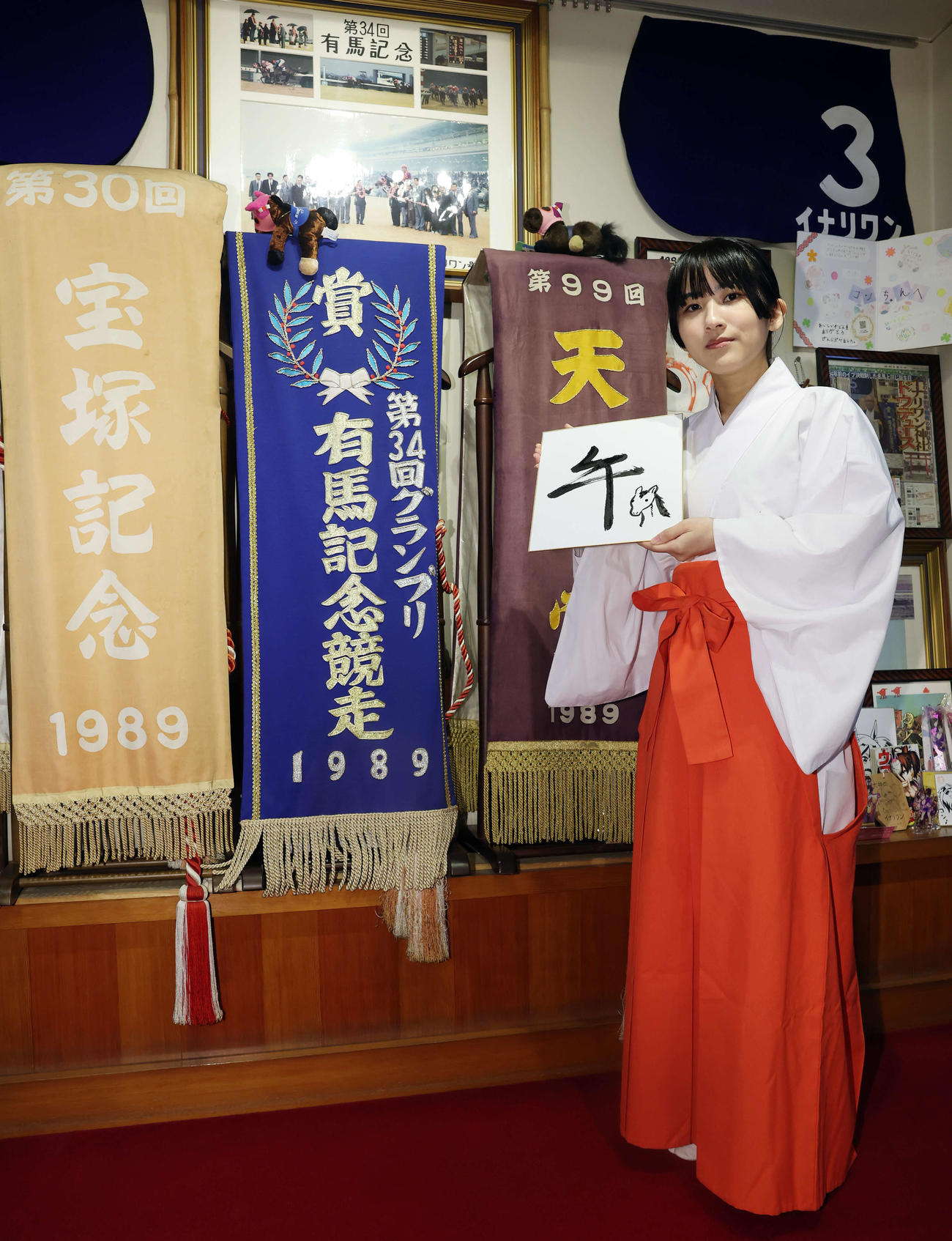 馬の絵を描いた色紙を手にする穴守稲荷神社の巫女の菊竹夏希さん（撮影・宮地輝）