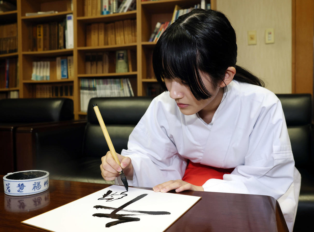 馬の絵を描く穴守稲荷神社の巫女の菊竹夏希さん（撮影・宮地輝）