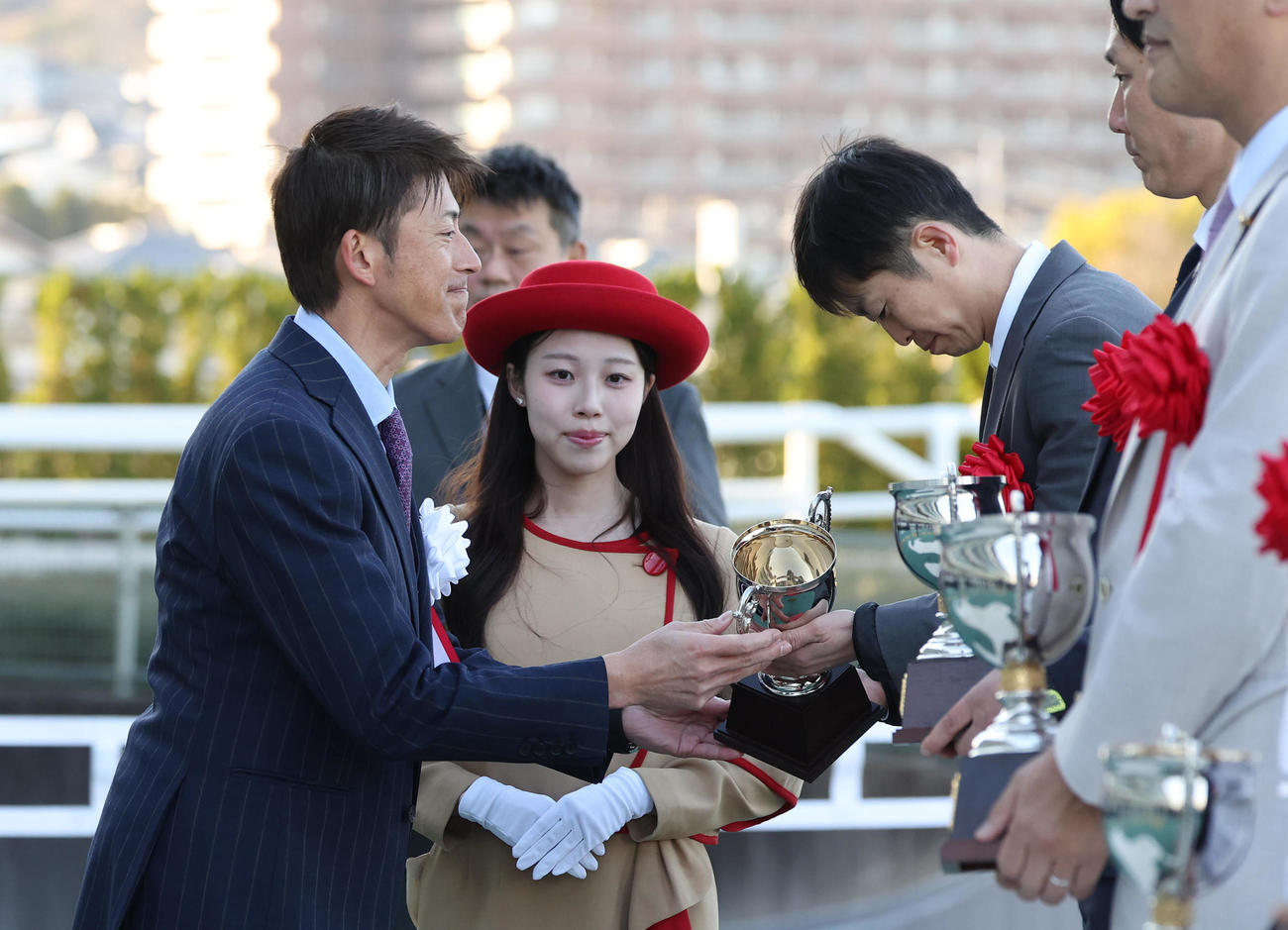 トロフィーを授与する能見氏（左）（撮影・白石智彦）
