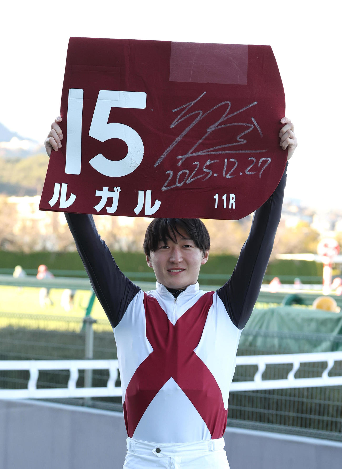 阪神11R、阪神Cを制してファンに勝利ゼッケンを掲げる鮫島駿騎手（撮影・白石智彦）